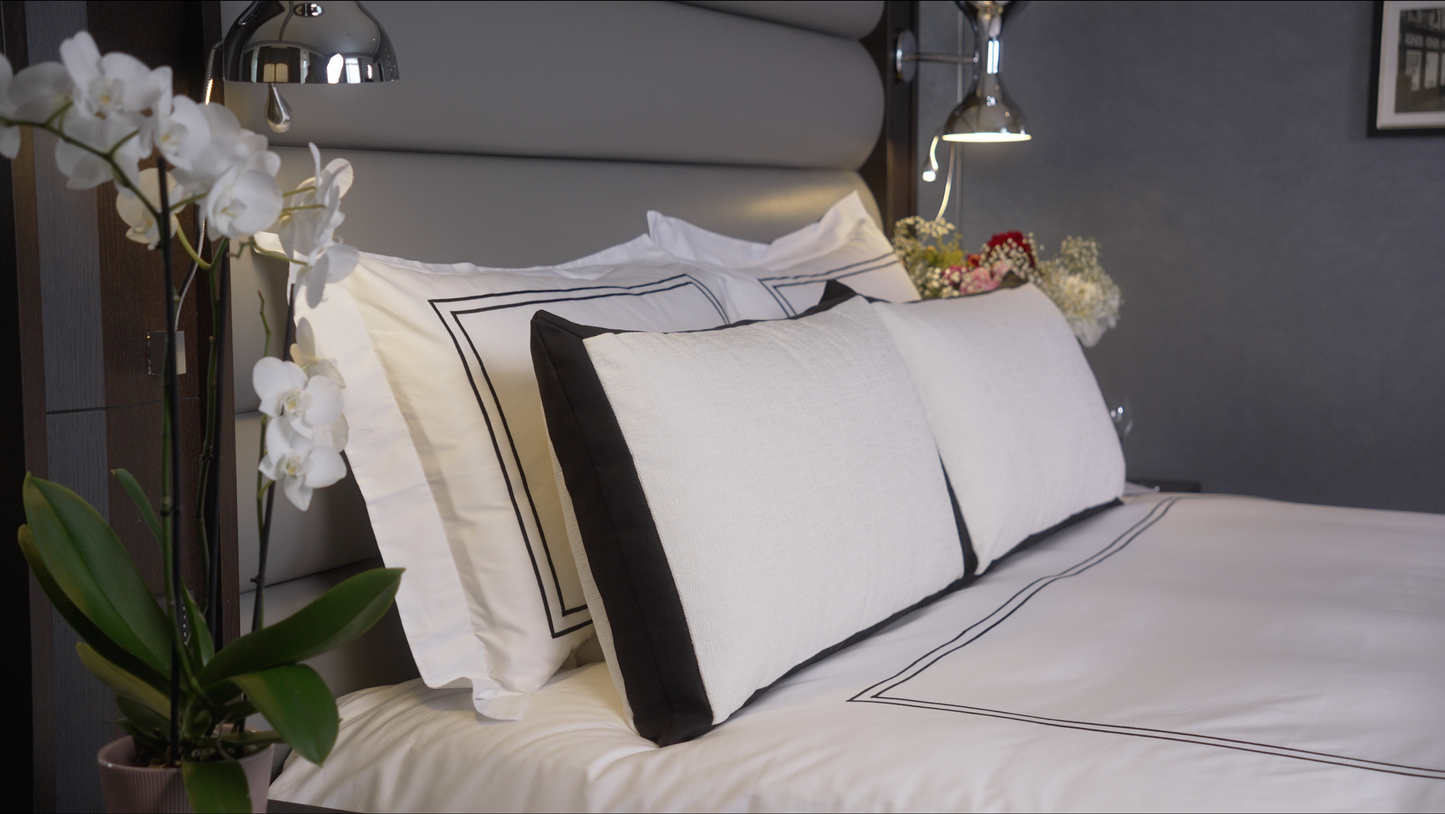 Luxury bed linen 300TC. Decorative cushions and orchids.
